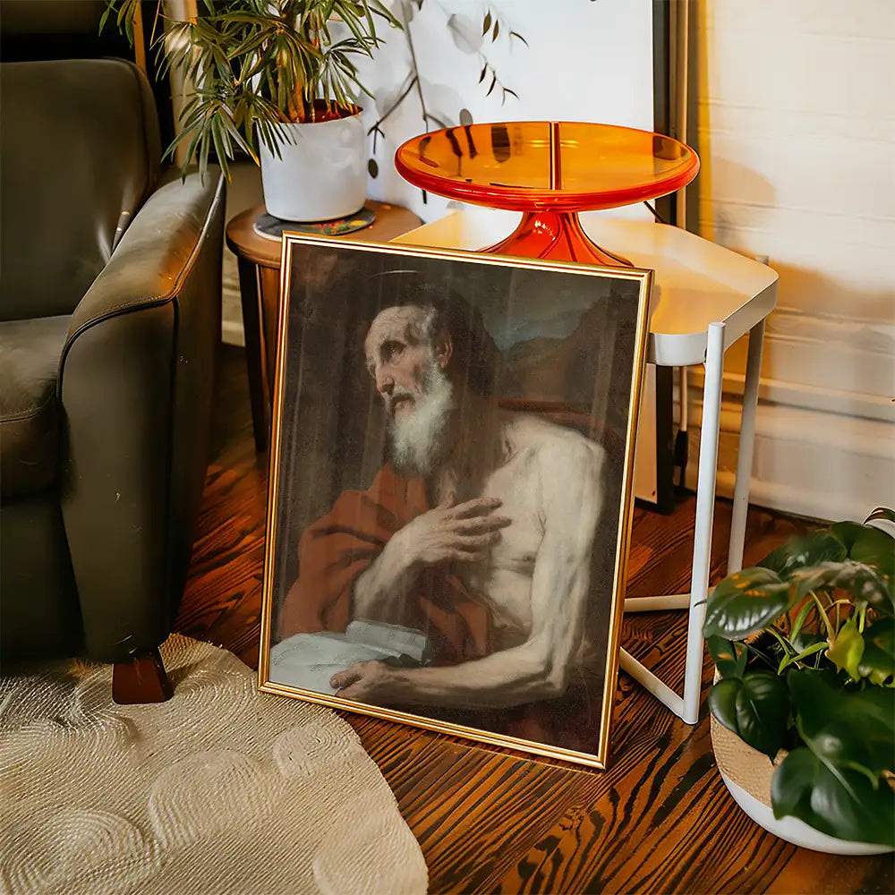 Framed painting of a bearded man draped in a red robe, seated with an expressive gesture, placed beside a plant and a small side table in a cozy living room setting.