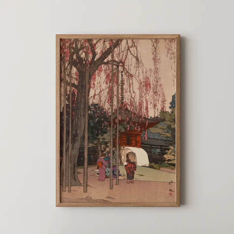 Framed painting featuring a serene landscape with a blossoming tree, a traditional building, and figures dressed in colorful attire, evoking a sense of tranquility and cultural rich heritage.