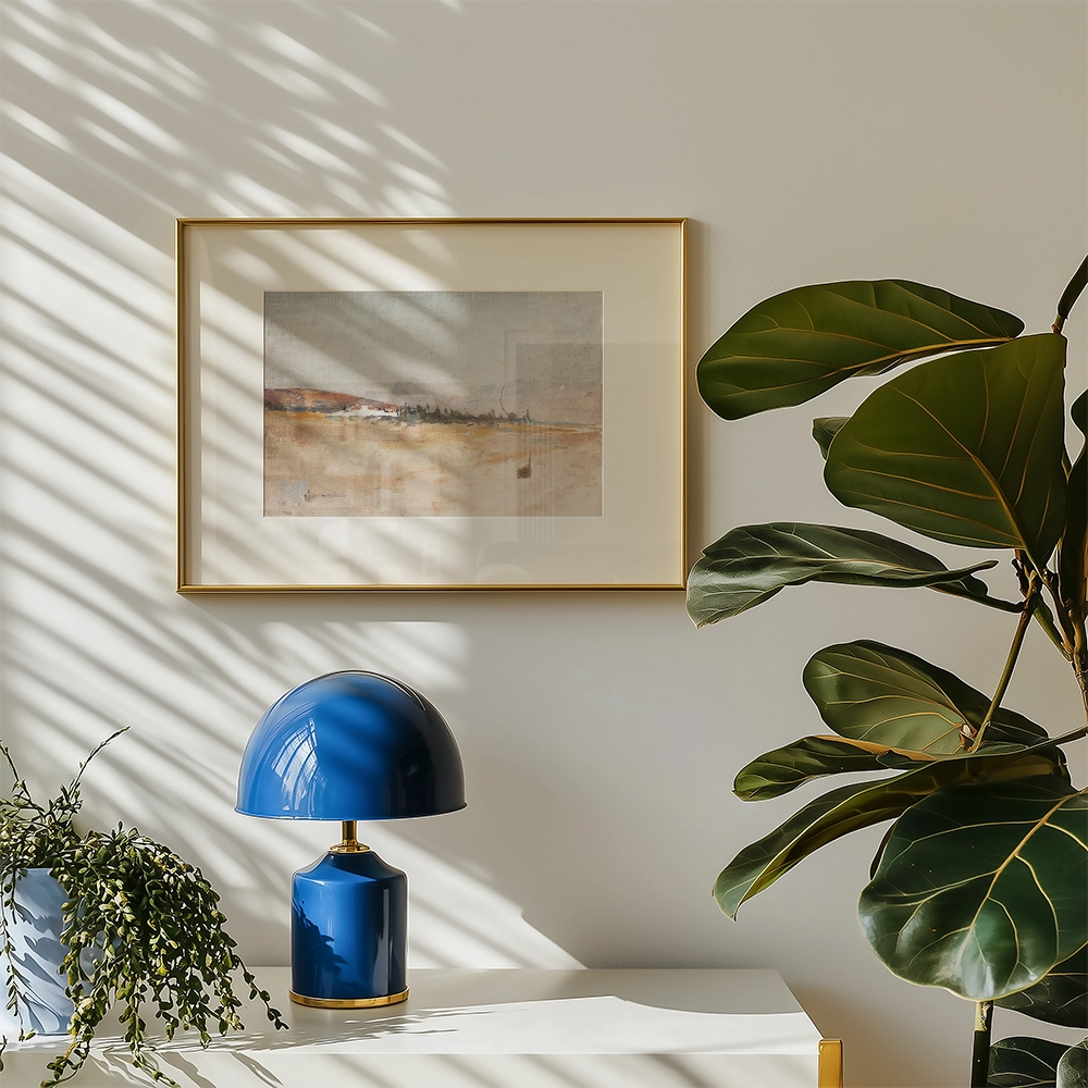 Framed painting on a wall with light shadows, accompanied by a blue lamp and a green plant.