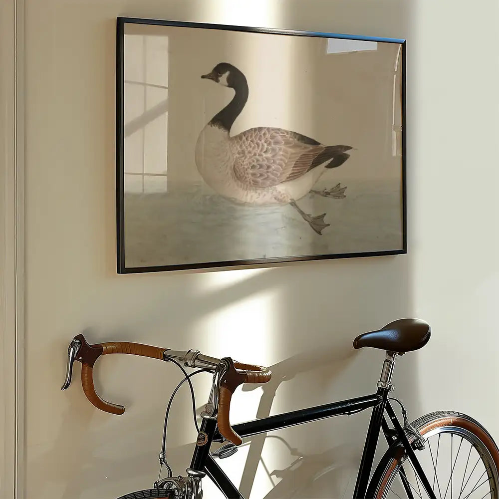 Framed painting of a goose displayed on a wall beside a vintage bicycle.