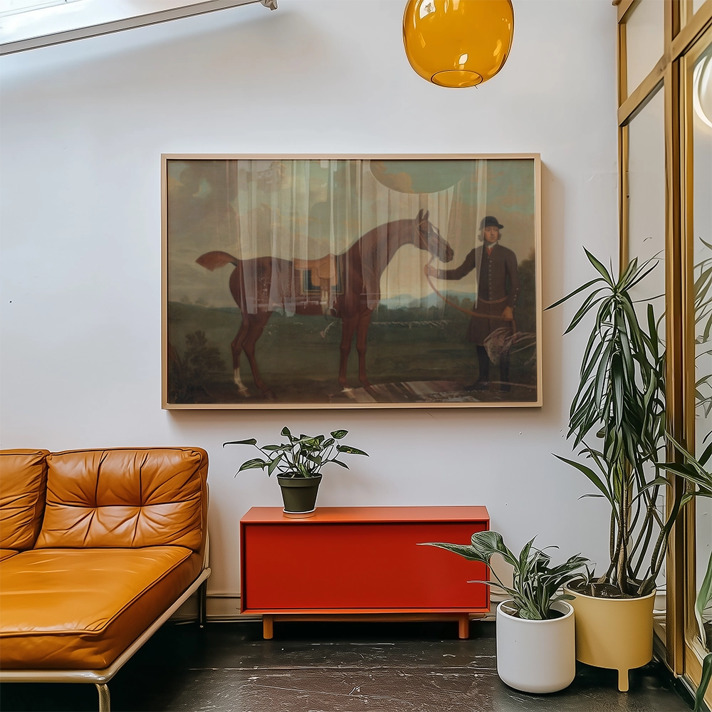 Framed vintage painting of a horse and a gentleman displayed on a wall in a modern living room with orange sofa and indoor plants.