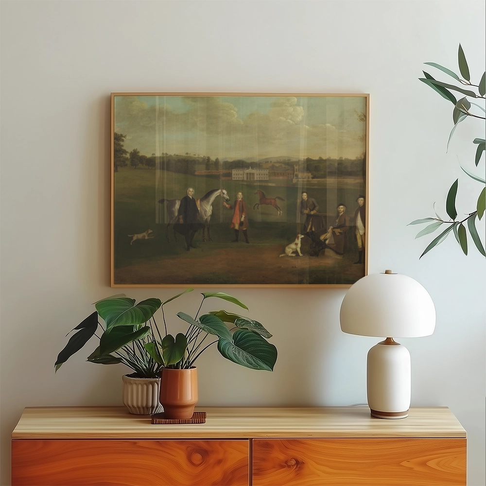 Painting of a rural scene featuring figures with horses and dogs, displayed in a framed setting on a modern wooden sideboard with plants and a lamp.