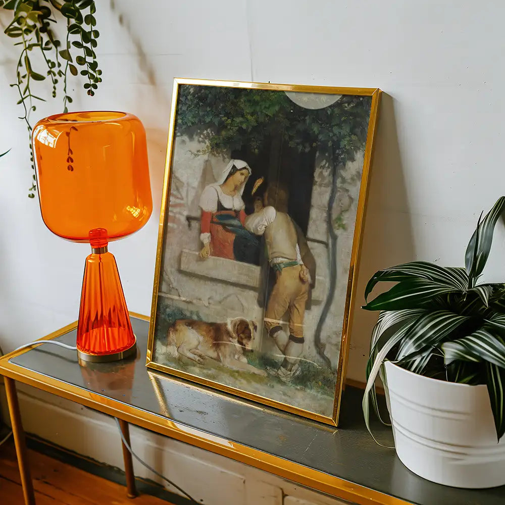 Painting of a woman and a man conversing in a rustic setting, framed in gold, displayed on a table next to an orange lamp and a potted plant.