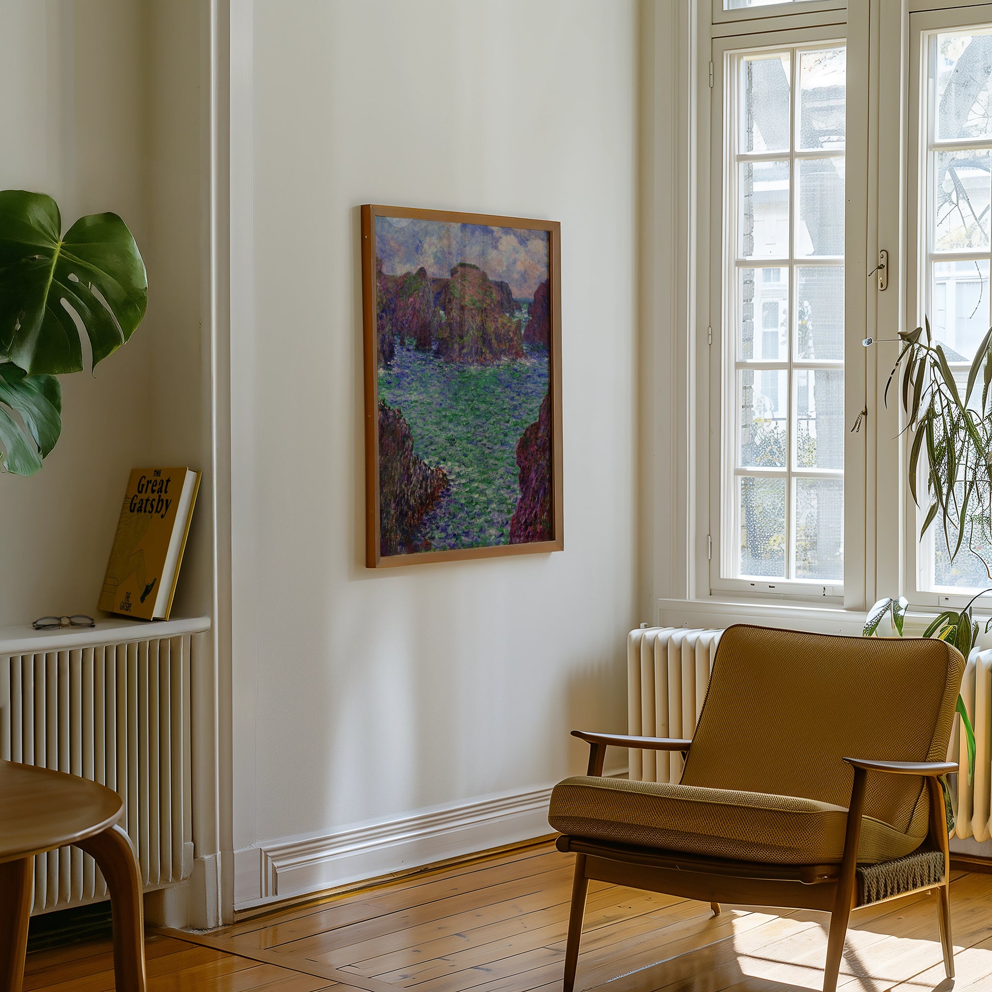 A framed painting depicting a serene landscape with green waters and rocky cliffs, displayed on a wall in a bright, minimalist interior featuring a modern armchair and indoor plants.