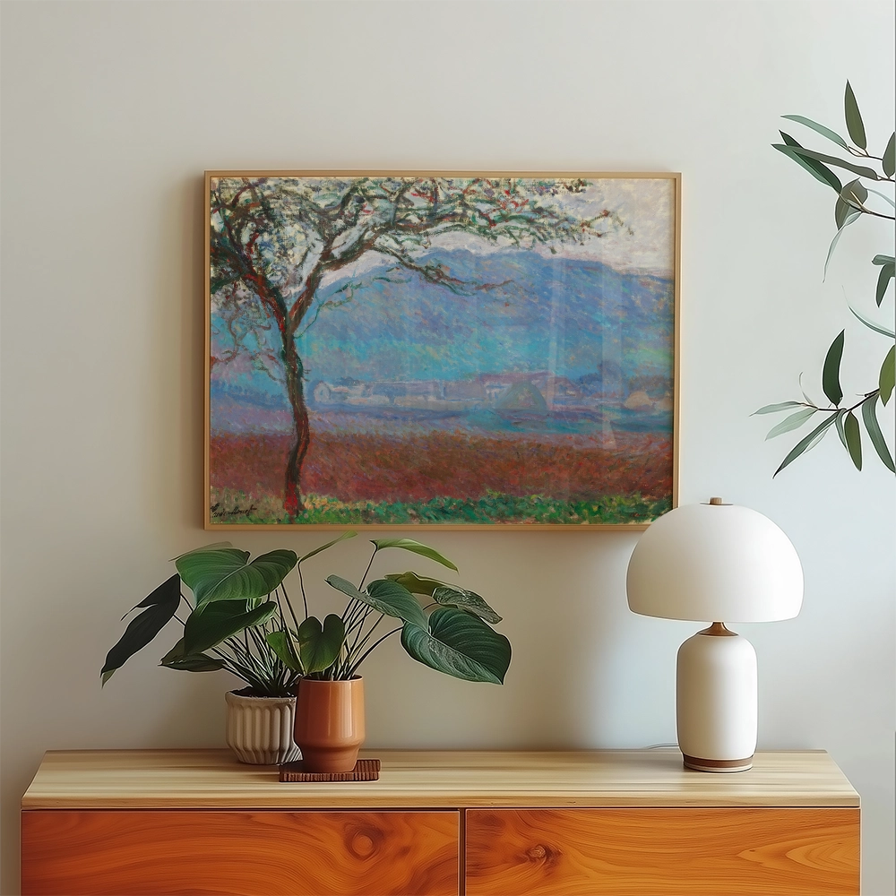 Framed painting of a tree and mountains displayed above a wooden sideboard with potted plants and a lamp.