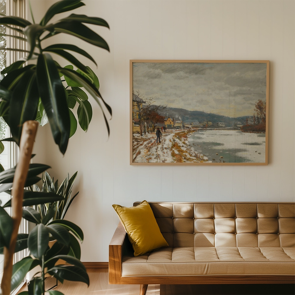 A landscape painting depicting a snowy riverbank with a figure walking, framed and displayed above a modern beige couch with a yellow cushion.