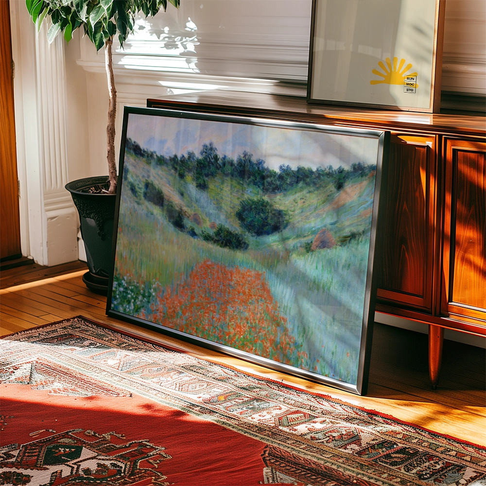 Framed painting of a lush hillside with colorful wildflowers leaning against a wooden cabinet under natural light.