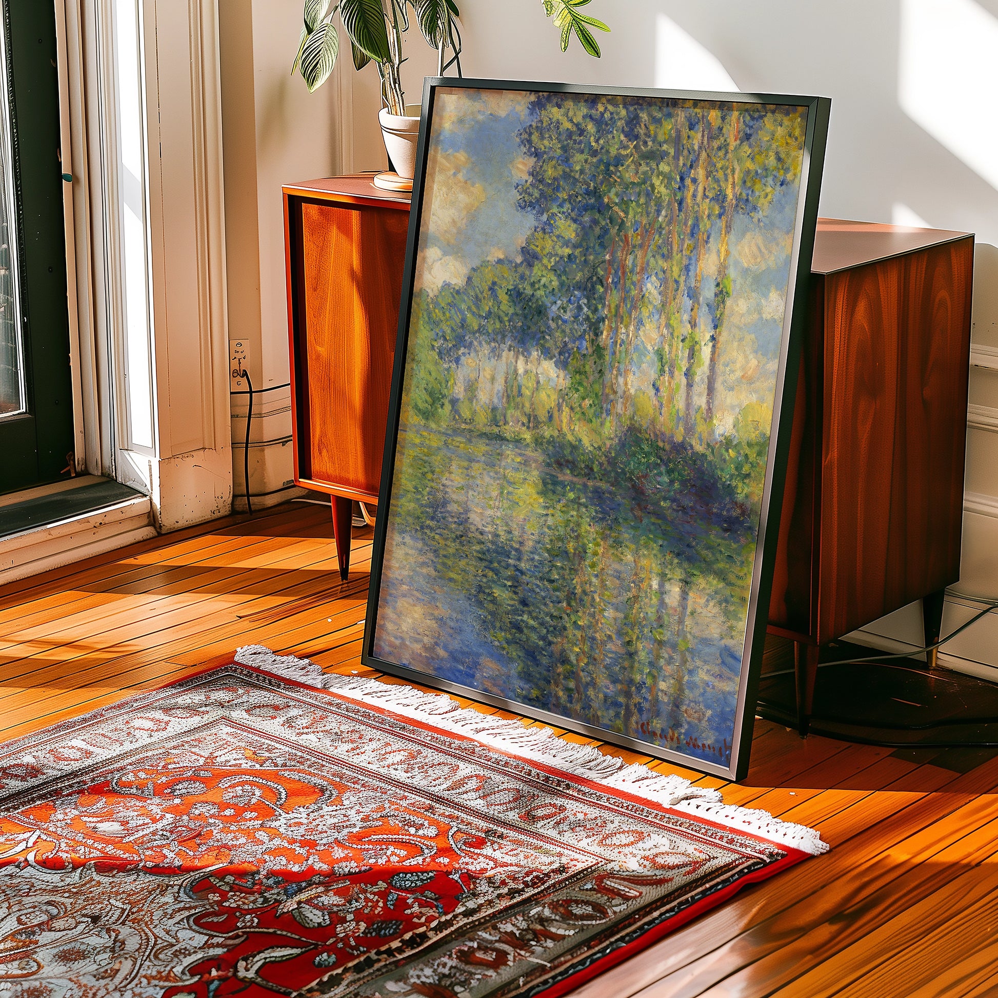 Framed painting of trees by a calm body of water in a stylish interior setting with wooden floors and a decorative rug.