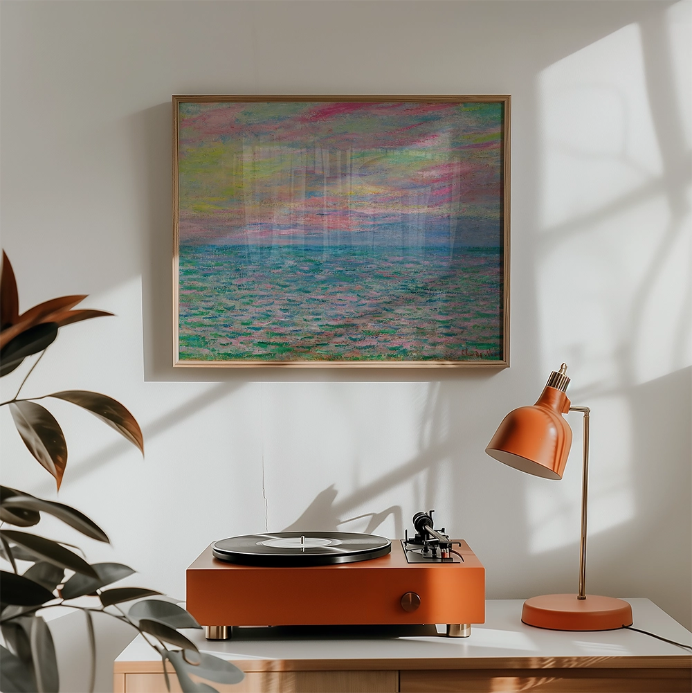 Framed painting of a serene ocean scene with pastel colors, above a modern orange record player and lamp in a well-lit interior setting.
