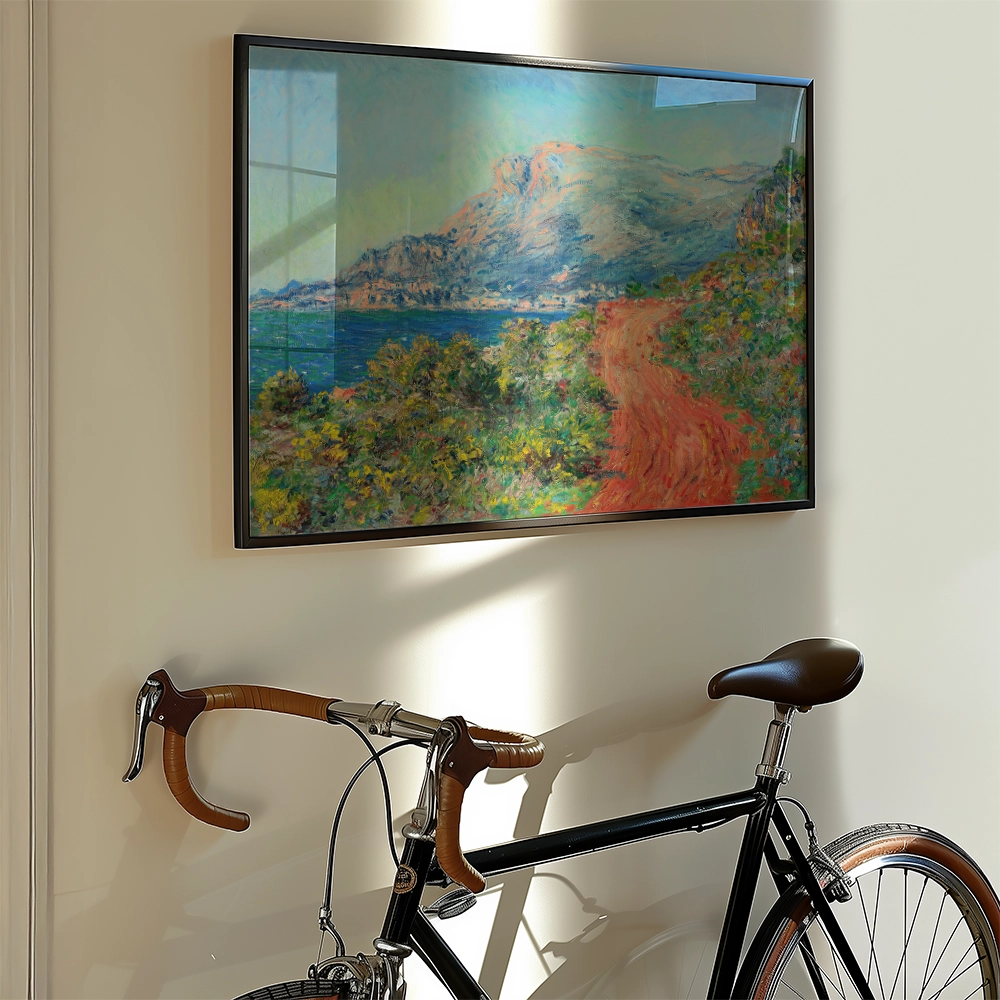 Landscape painting of a coastal scene with mountains, displayed on a wall next to a vintage bicycle.