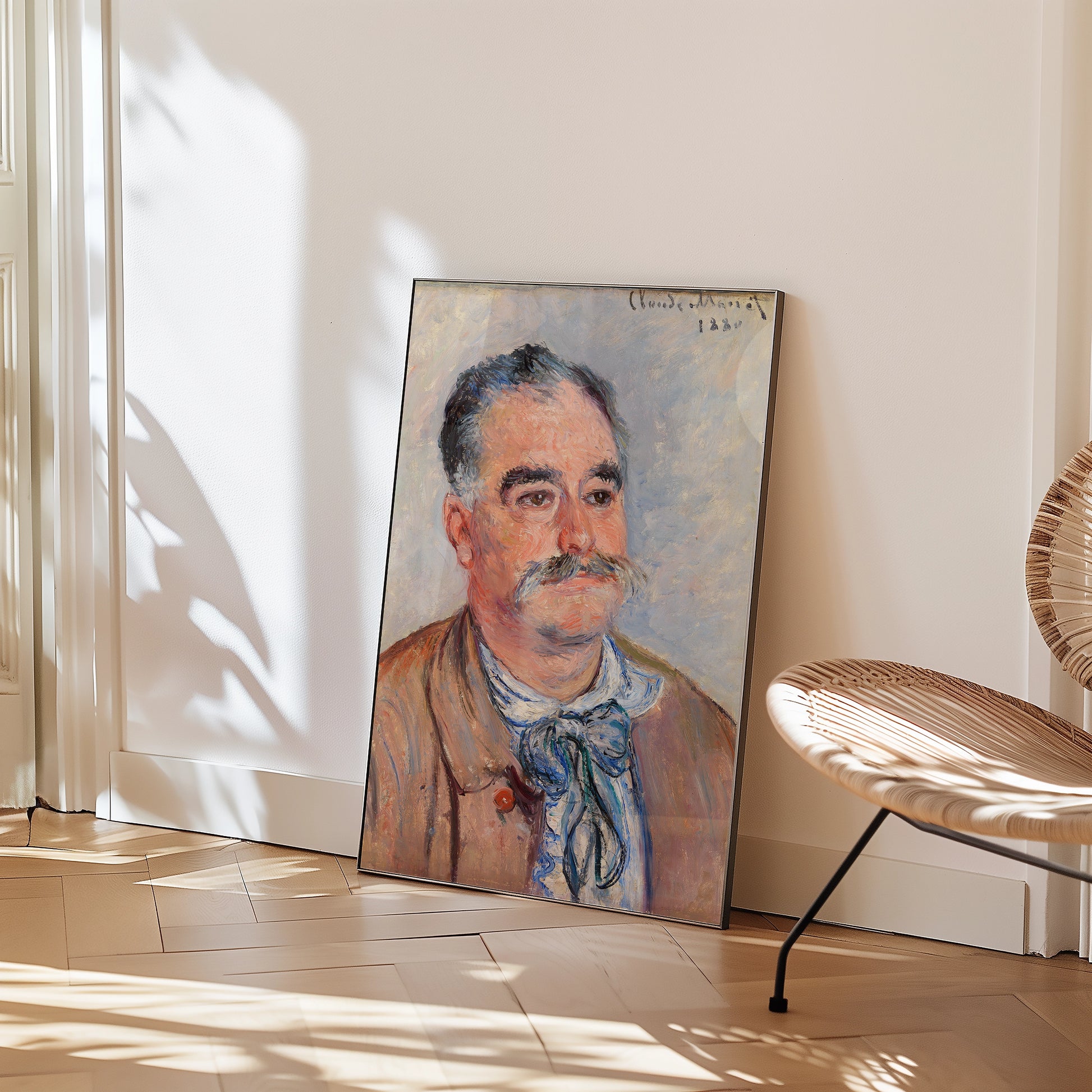 Portrait painting of a man with a mustache, displayed on the floor next to a chair in a modern interior setting.