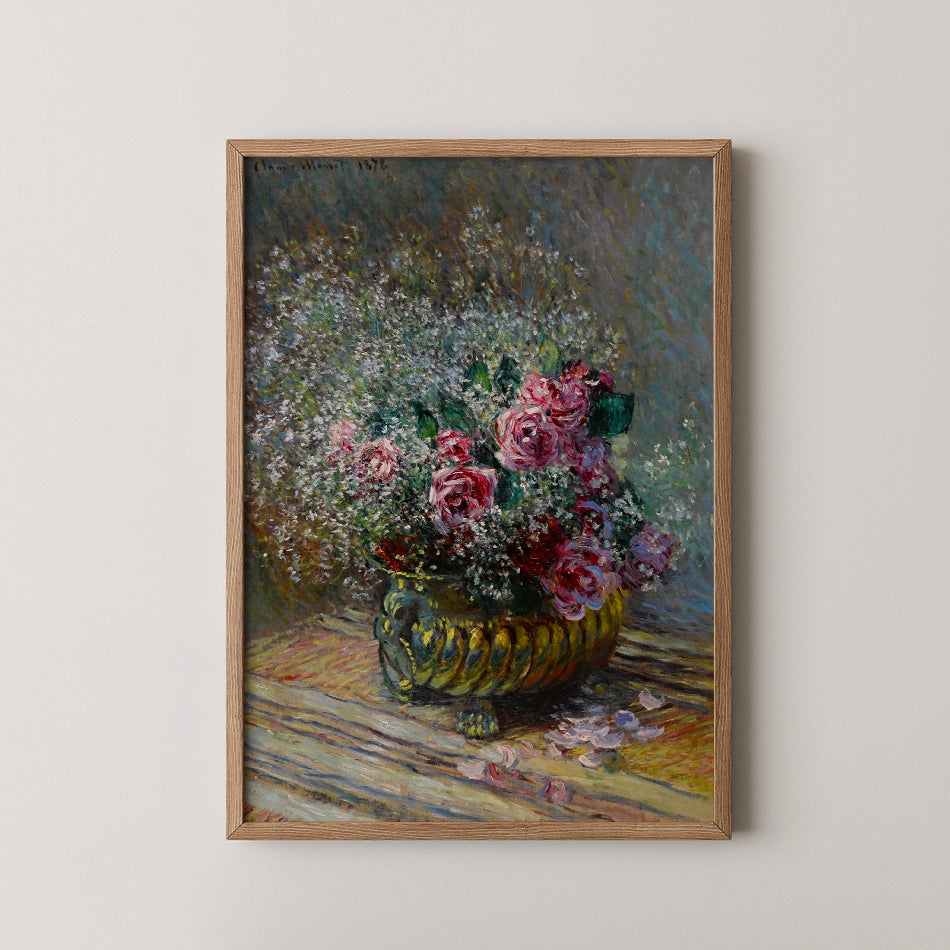 A vibrant painting of a bouquet of pink roses and white flowers in a decorative yellow vase, framed and displayed on a light-colored wall.