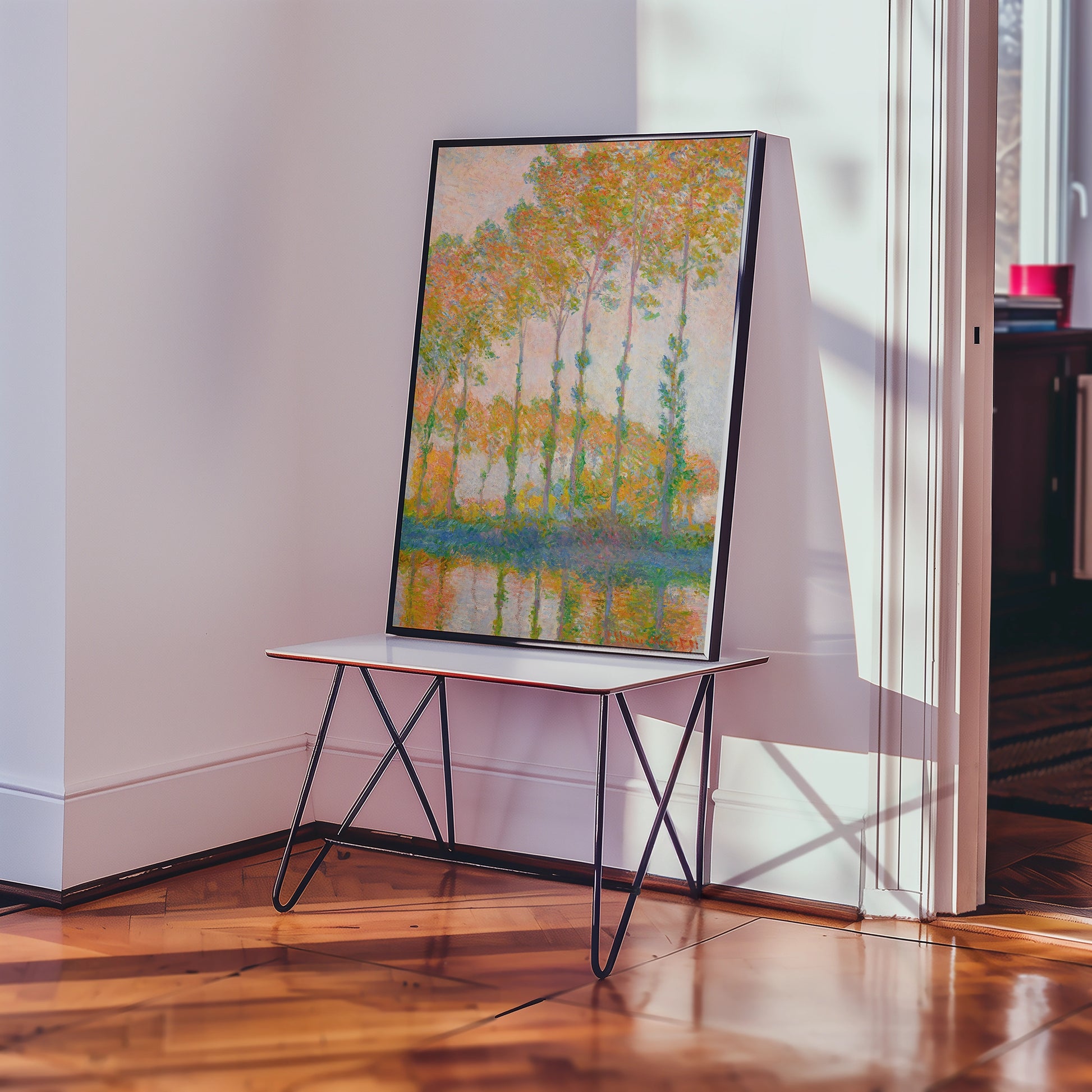 A vibrant painting of trees reflecting in water, displayed on a modern table in a bright interior setting.