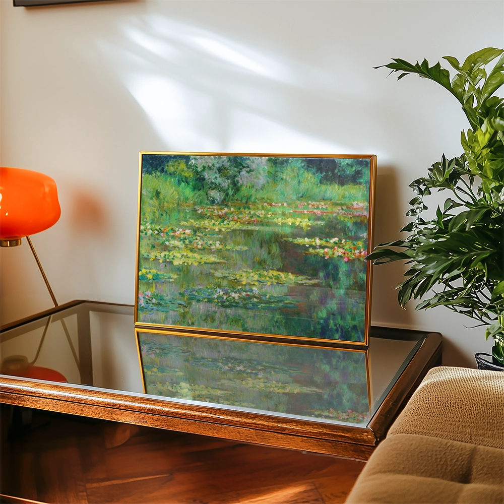 Framed painting of a serene water lily pond displayed on a wooden coffee table under soft natural light.