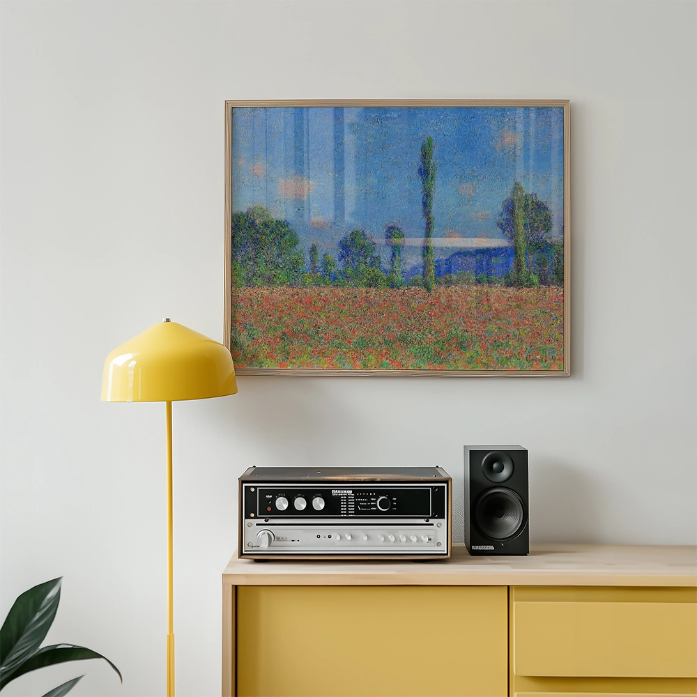 Painting of a vibrant landscape with blue sky and green trees, framed and displayed above a yellow lamp and a vintage stereo system on a wooden sideboard.