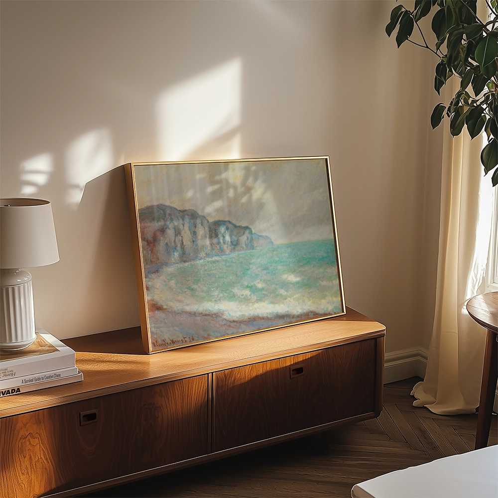 A serene coastal painting with soft colors, displayed on a wooden console in a sunlit room, accompanied by a lamp and decorative books.