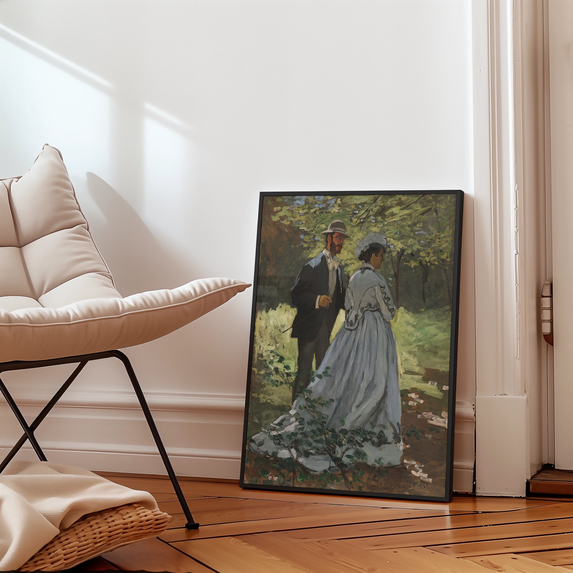 Framed painting of a couple walking in a lush green garden, positioned next to a modern chair in a bright interior setting.