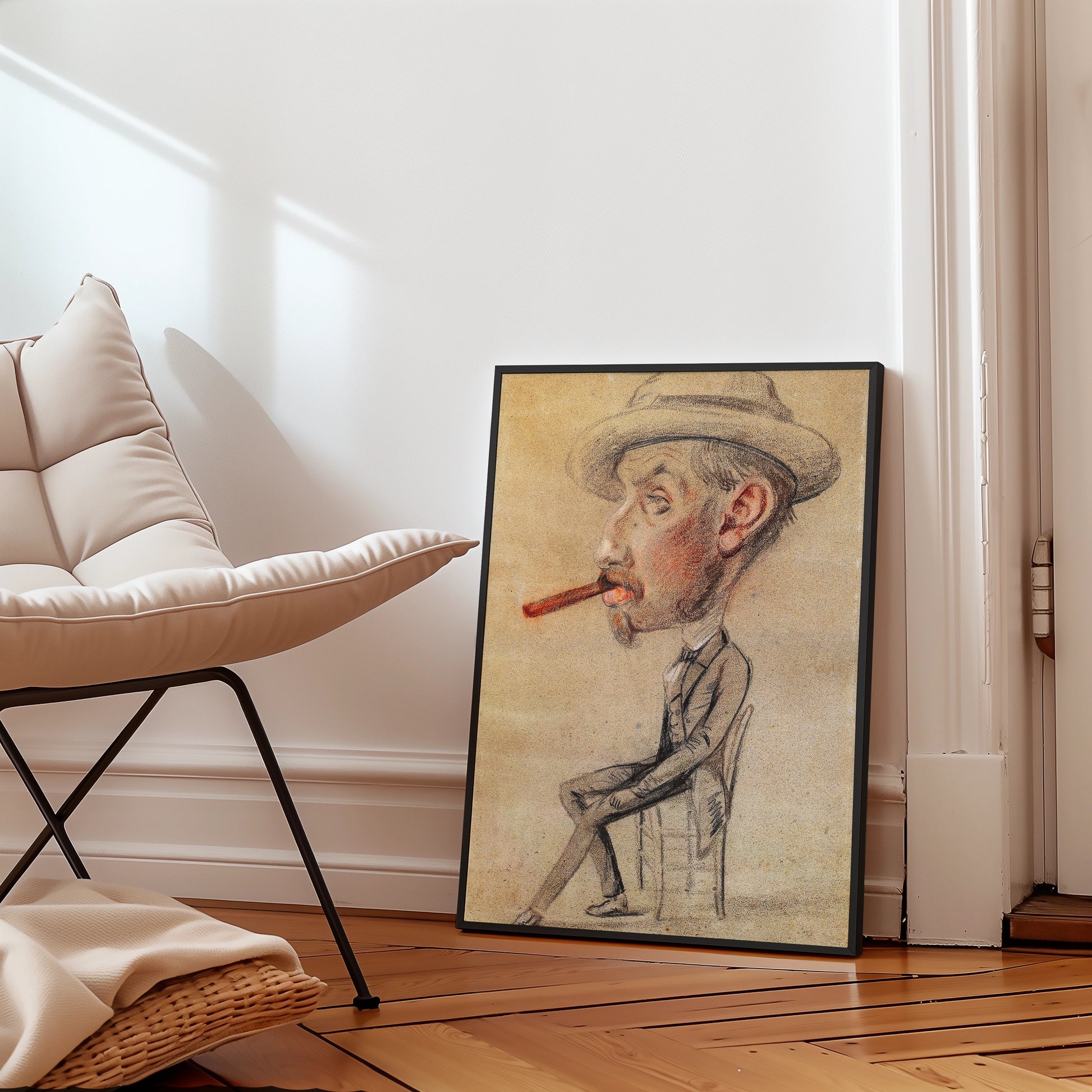 Framed caricature painting of a man sitting with a cigar, leaning on a chair, placed on a wooden floor next to a modern chair.