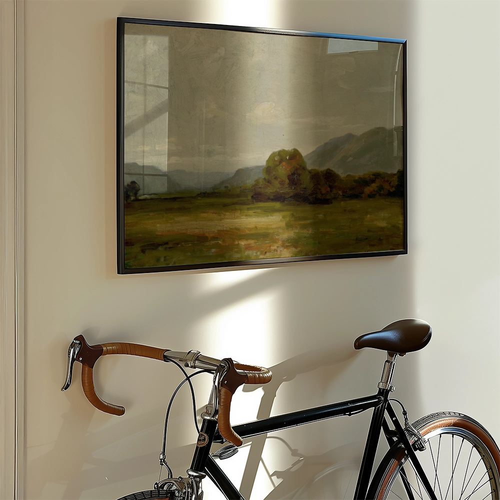 Painting of a serene landscape featuring rolling hills and trees, displayed on a wall next to a vintage bicycle.