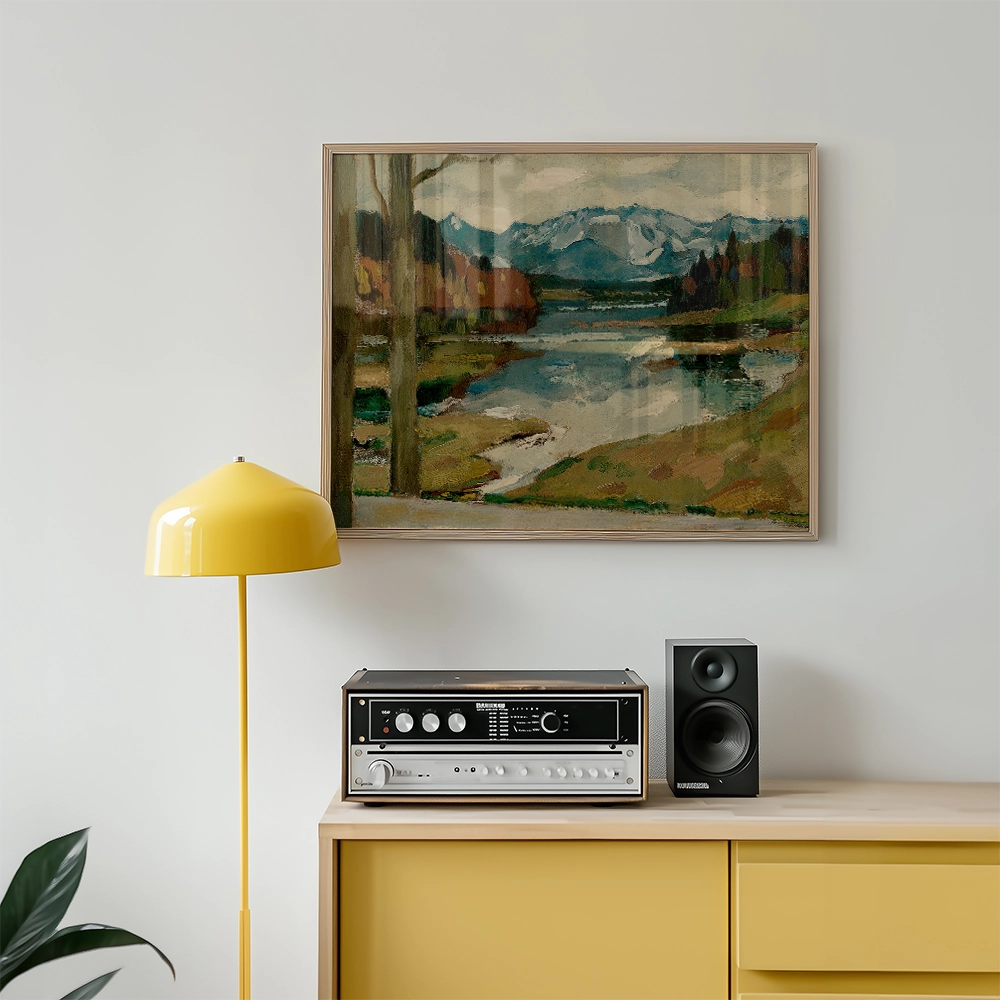 Landscape painting featuring mountains and a river, framed and hung above a vintage audio system and a yellow floor lamp in a modern living space.