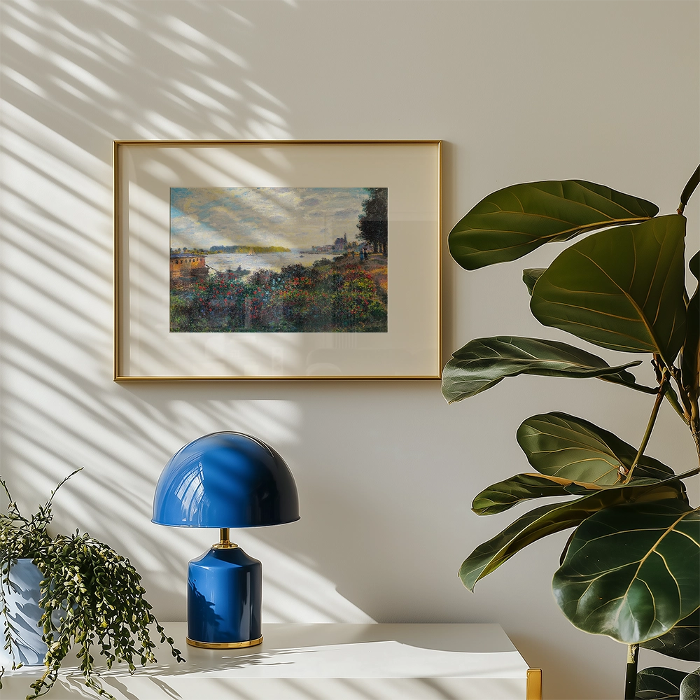 Framed painting of a landscape with flowers and water, displayed on a wall next to a blue lamp and a green plant.