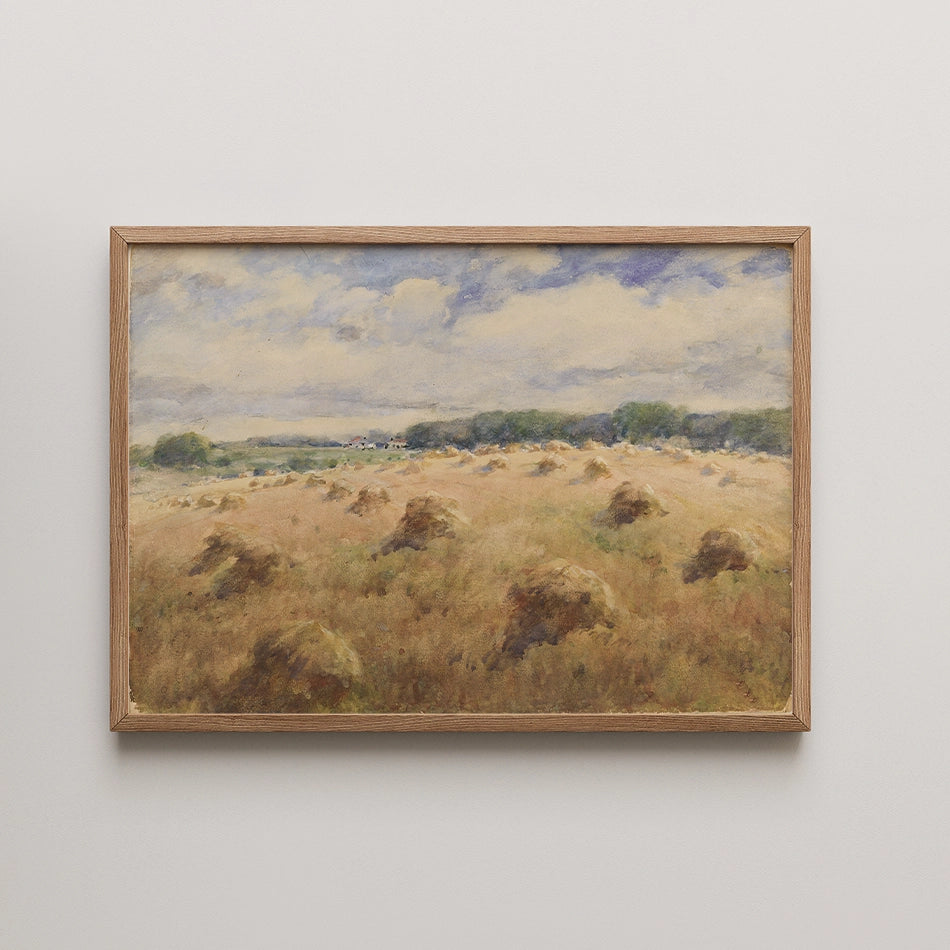 Landscape painting depicting a golden field with haystacks under a partly cloudy sky, framed in natural wood.
