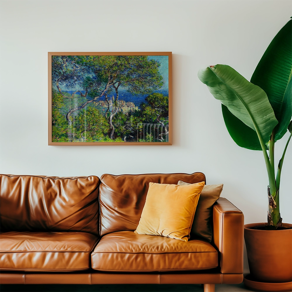 Framed painting of a scenic landscape with trees and blue sky, displayed above a brown leather sofa with a yellow throw pillow and a green potted plant.