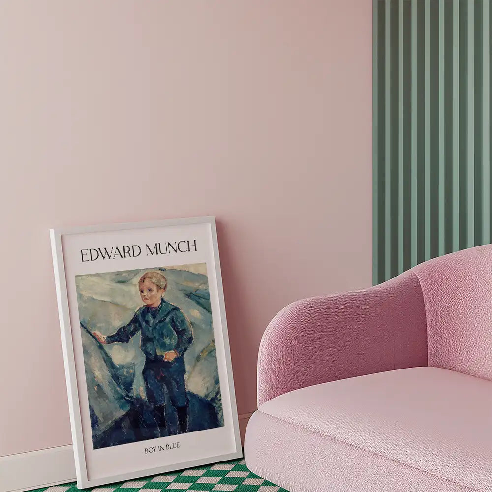 Framed painting of "Boy in Blue" by Edward Munch leaning against a wall, with a pink chair in the foreground.