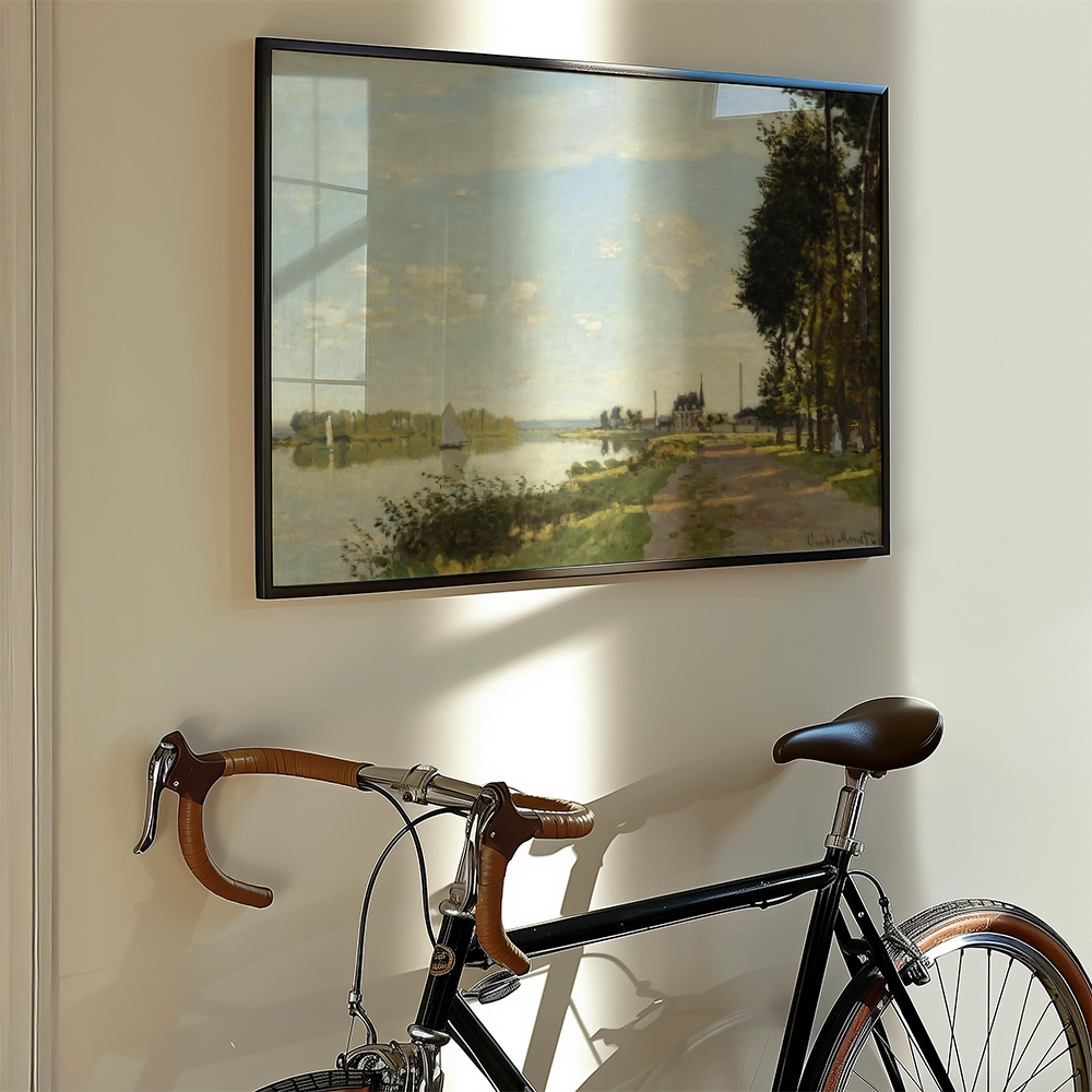 Framed painting of a serene landscape depicting a river with sailboats, trees lining the shore, and a path beside a bicycle.