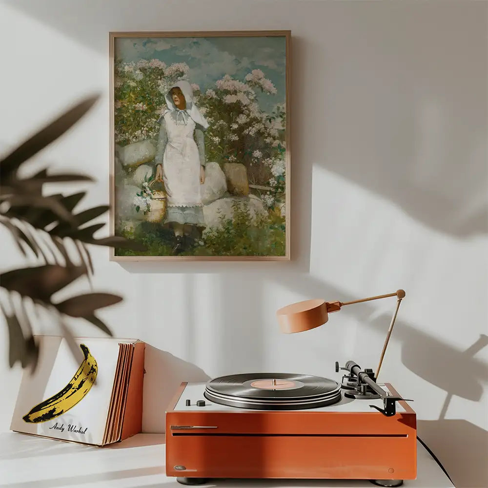 A framed painting of a woman in a white apron standing amidst flowering bushes, displayed above a vintage record player and surrounded by decor elements.