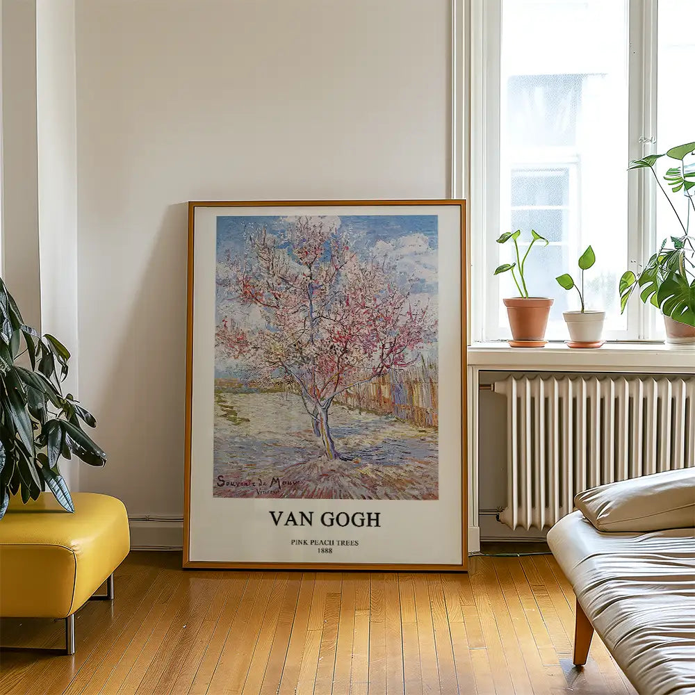 Framed artwork of Van Gogh's "Pink Peach Trees" (1888) displayed in a bright room with indoor plants and wooden flooring.