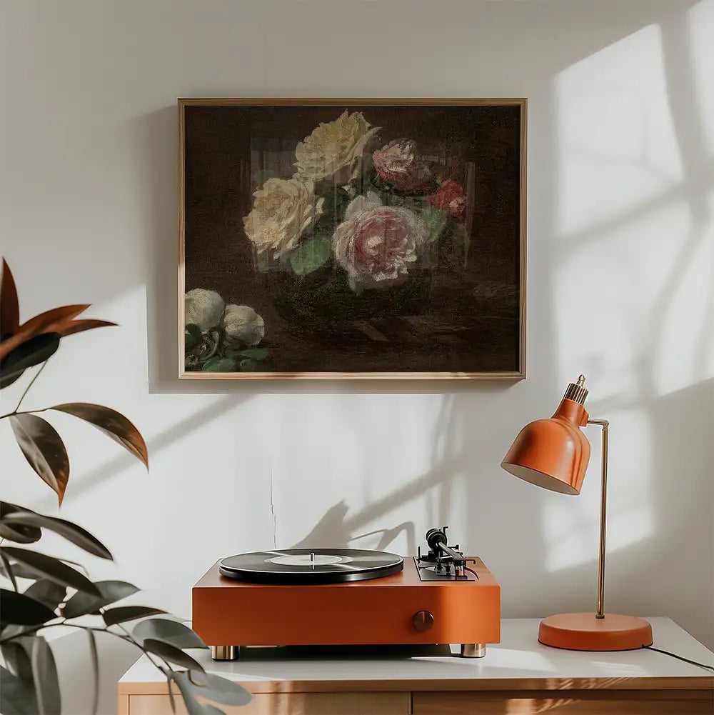 Painting of roses in a vase framed on a wall, with an orange turntable and lamp in a stylish interior setting.