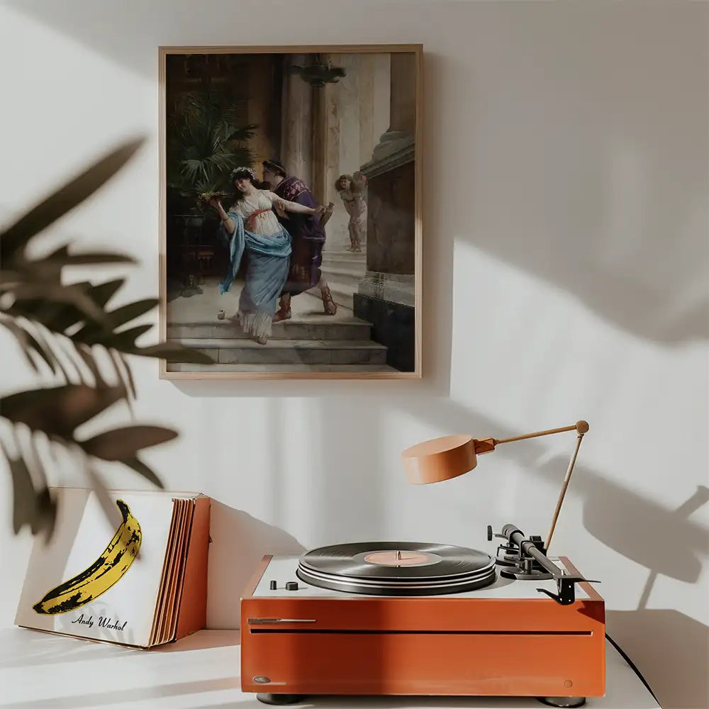 Vintage painting of a woman in a blue dress being assisted by a man in a purple outfit, framed and hung on a wall above a turntable and a banana art print.