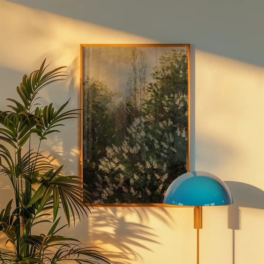 Framed painting of lush greenery and flowers on a wall next to a potted plant and a modern blue lamp.