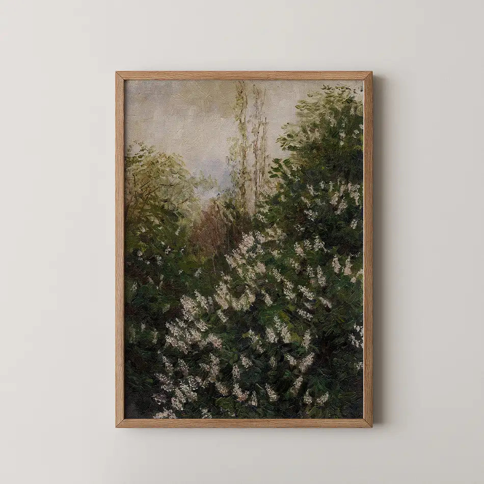 A framed painting of a green and white floral landscape with trees, displayed on a light wall.