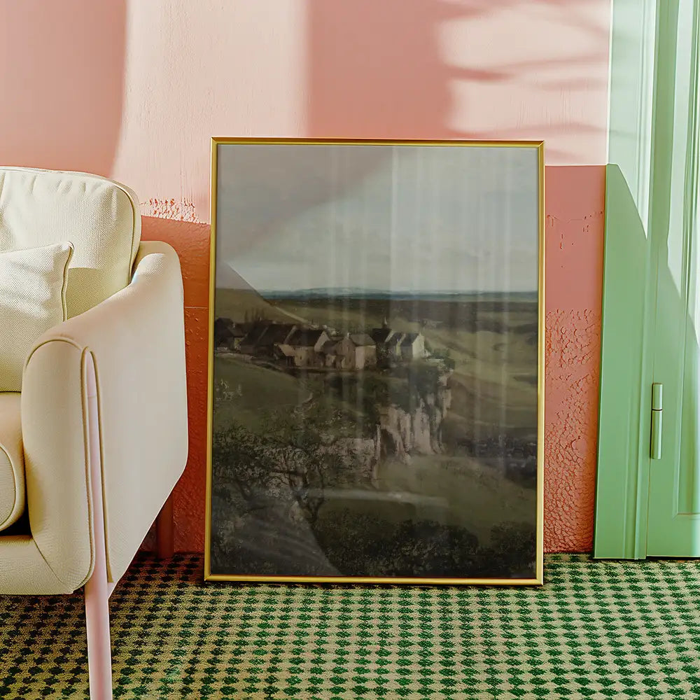 Muted landscape painting with golden frame leaning against a pastel wall in a modern living space.