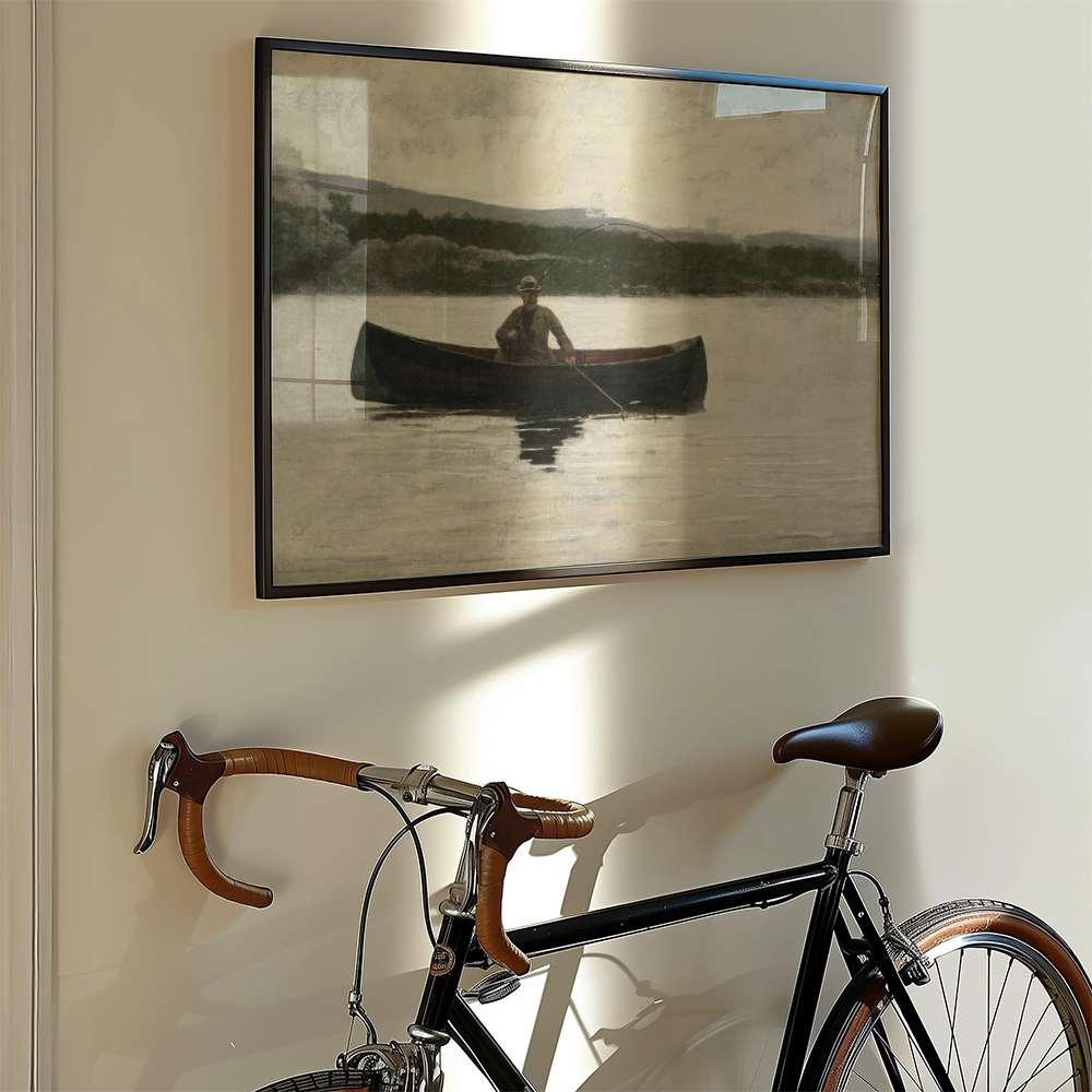 Framed painting of a solitary figure in a canoe on a calm lake, displayed on a wall alongside a vintage bicycle.