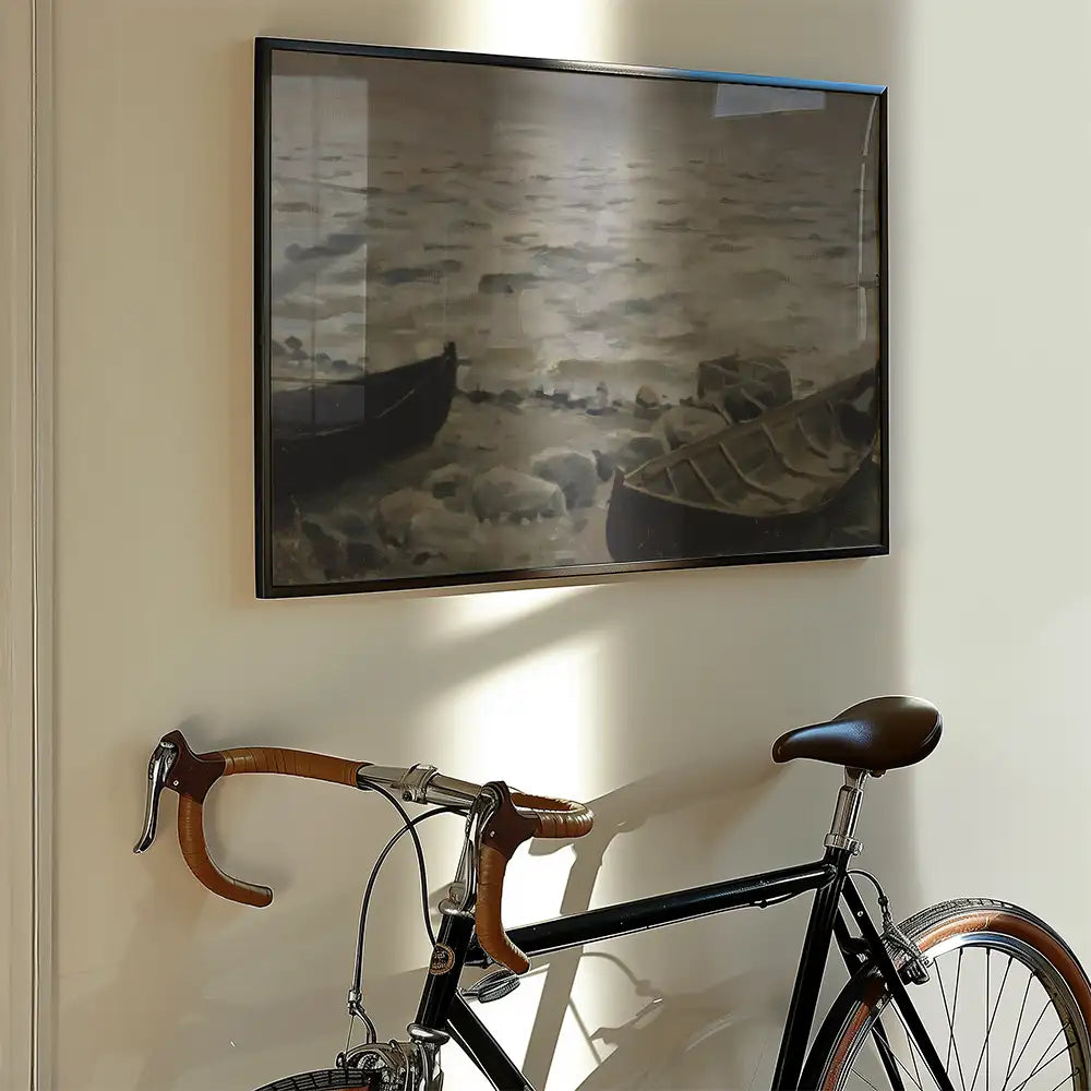 Painting of boats on water framed and displayed on a wall next to a black bicycle.