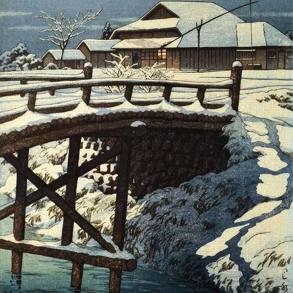 Snow-covered bridge over a stream with traditional Japanese houses in the background during winter night.