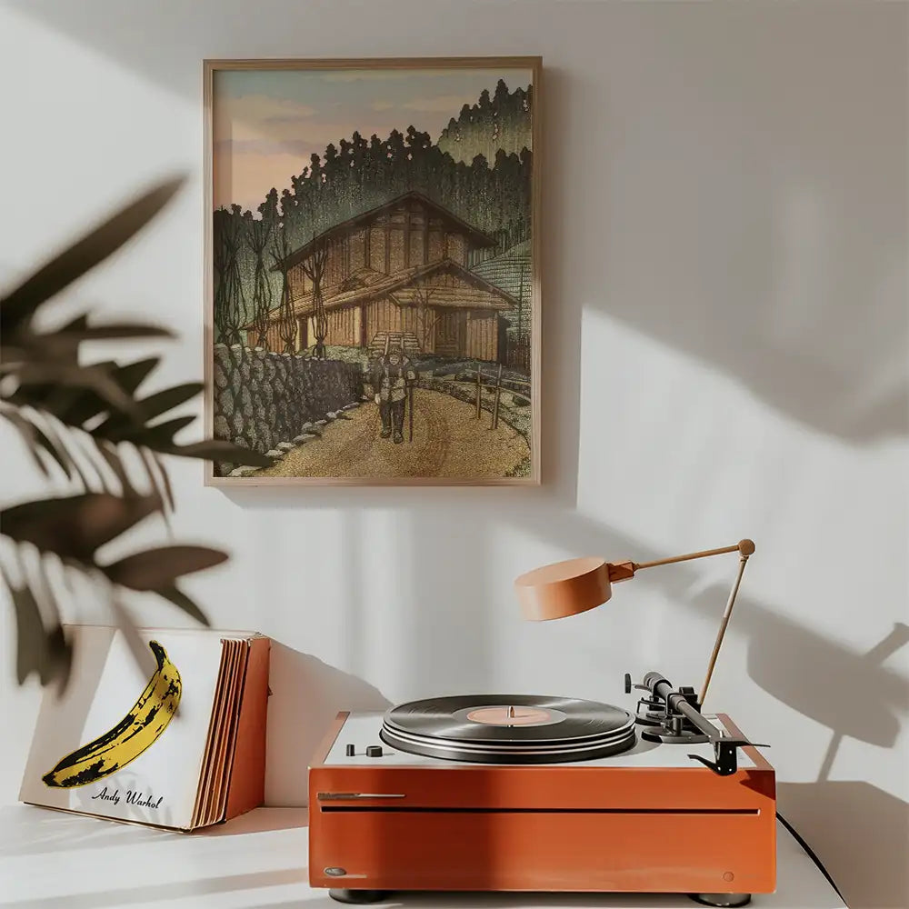 Artistic painting of a serene cottage landscape framed on the wall, with a vintage record player and potted plant in the foreground.