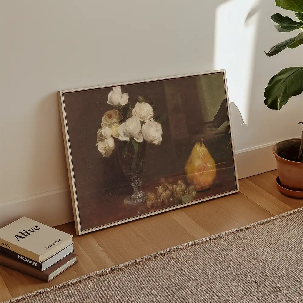 Painting of white roses in a glass vase with a pear and grapes, leaning against a wall next to stacked books.