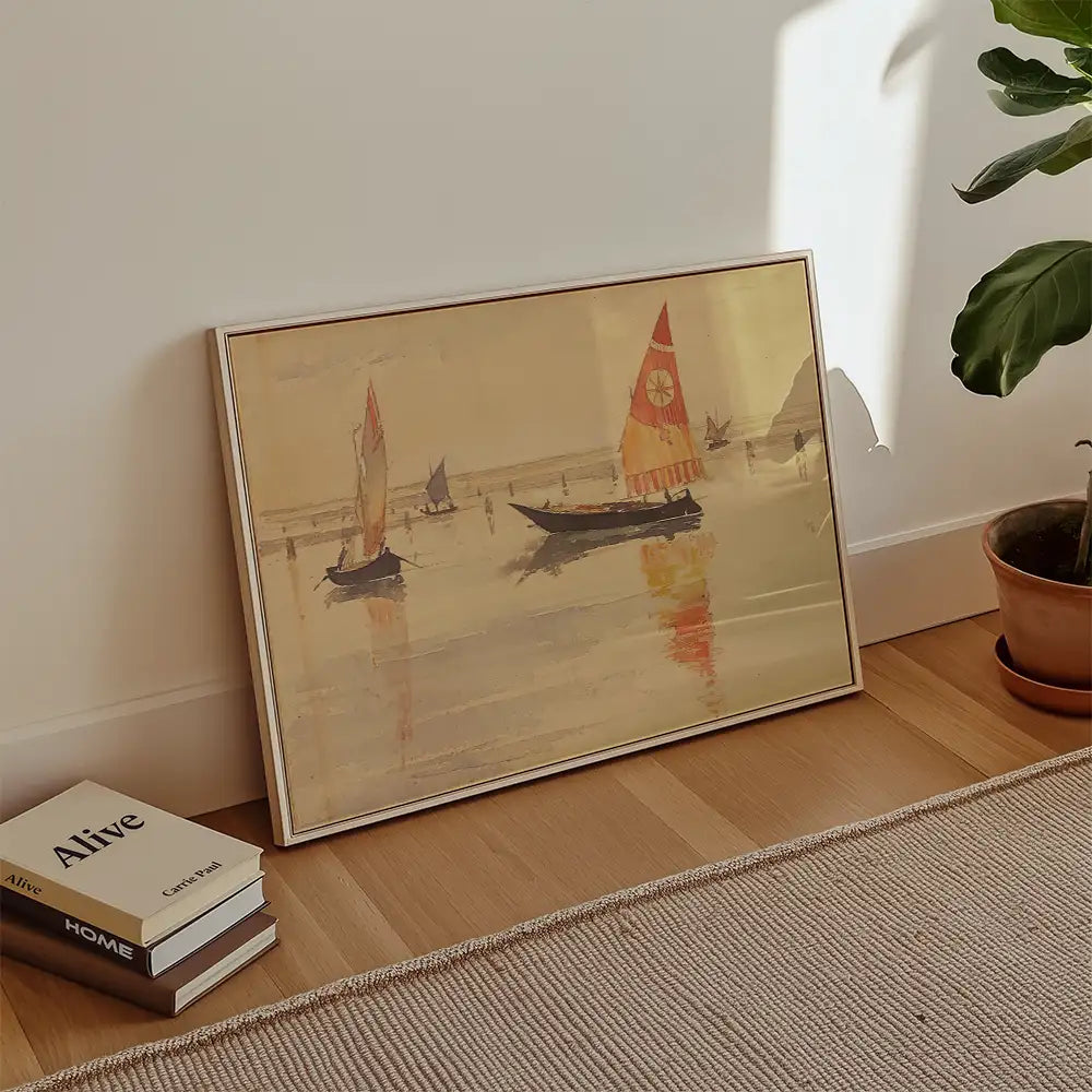 Framed painting of sailboats on calm water, leaning against a wall with books and a potted plant nearby.
