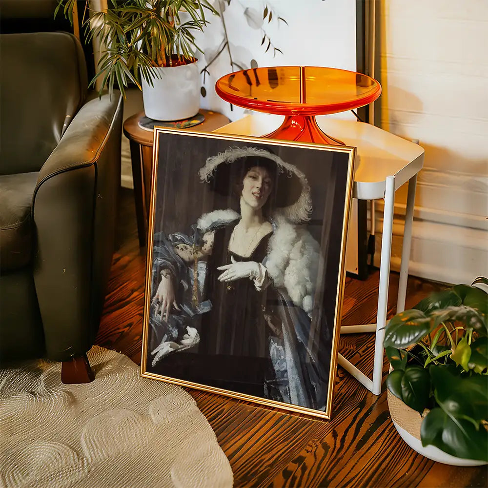 Framed painting of a woman in a black dress and hat with feathers, leaning against a decorative chair next to a modern side table and plants.