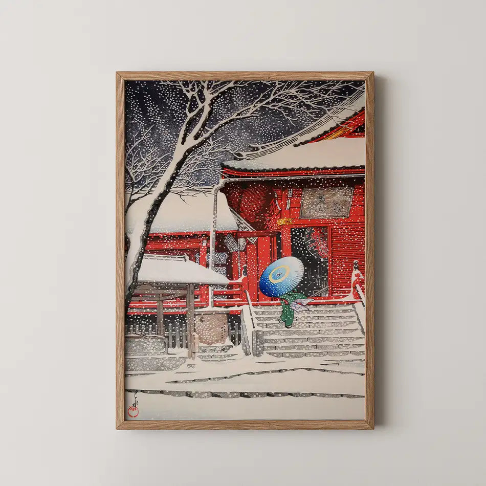 Snowy landscape painting featuring a red building and a figure with a colorful umbrella, framed in wood.