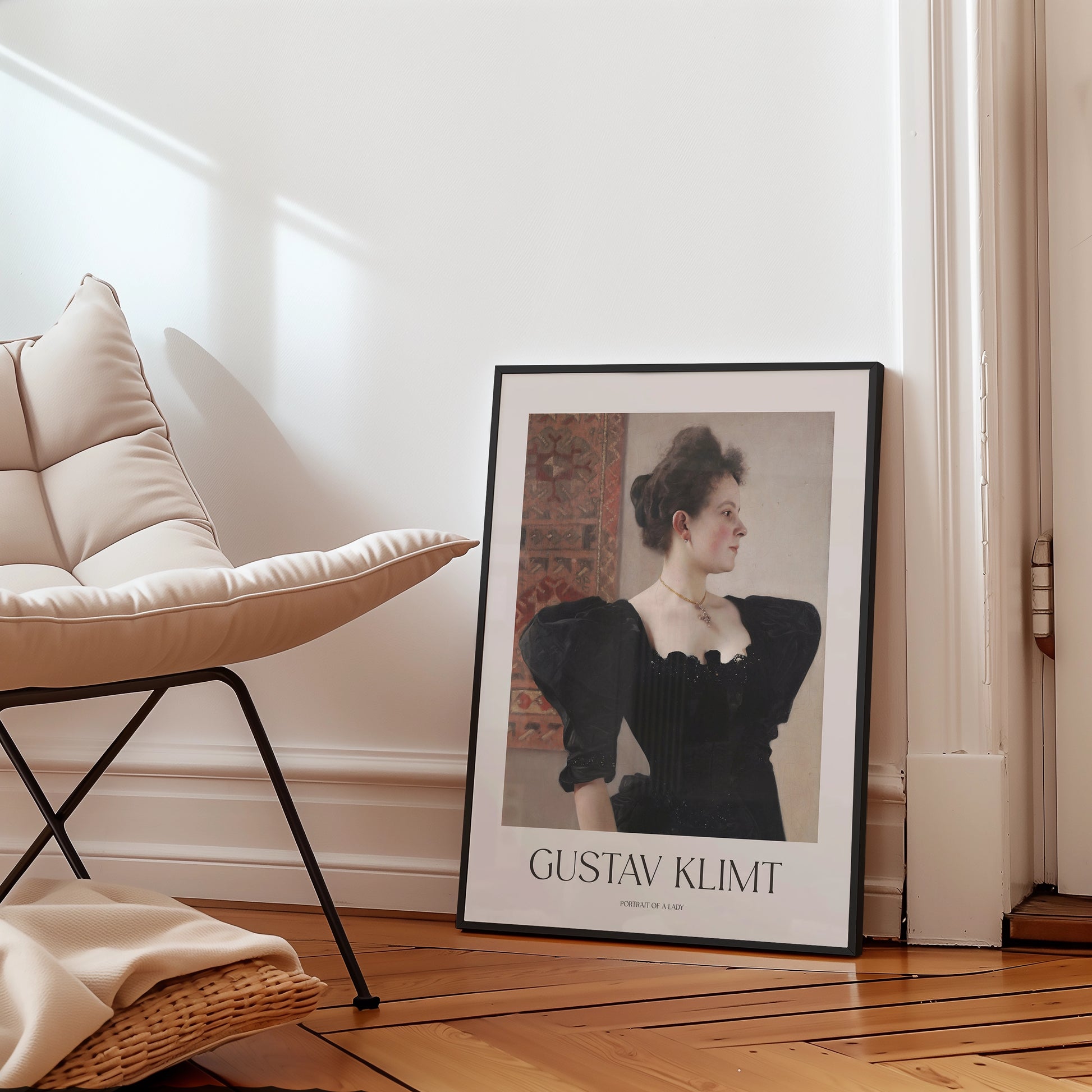 Framed poster of Gustav Klimt's "Portrait of a Lady" leaning against a wall next to a modern chair in a stylish interior setting.