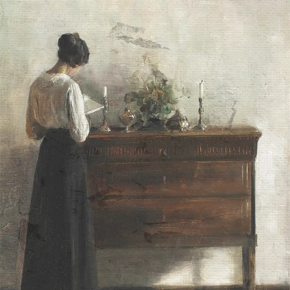 Painting of a woman reading beside a wooden chest of drawers adorned with candles and decorative items, set against a softly lit wall.