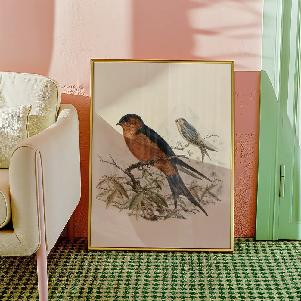 Painting of two birds perched on a branch, framed and displayed beside a light-colored armchair in a stylish interior setting.