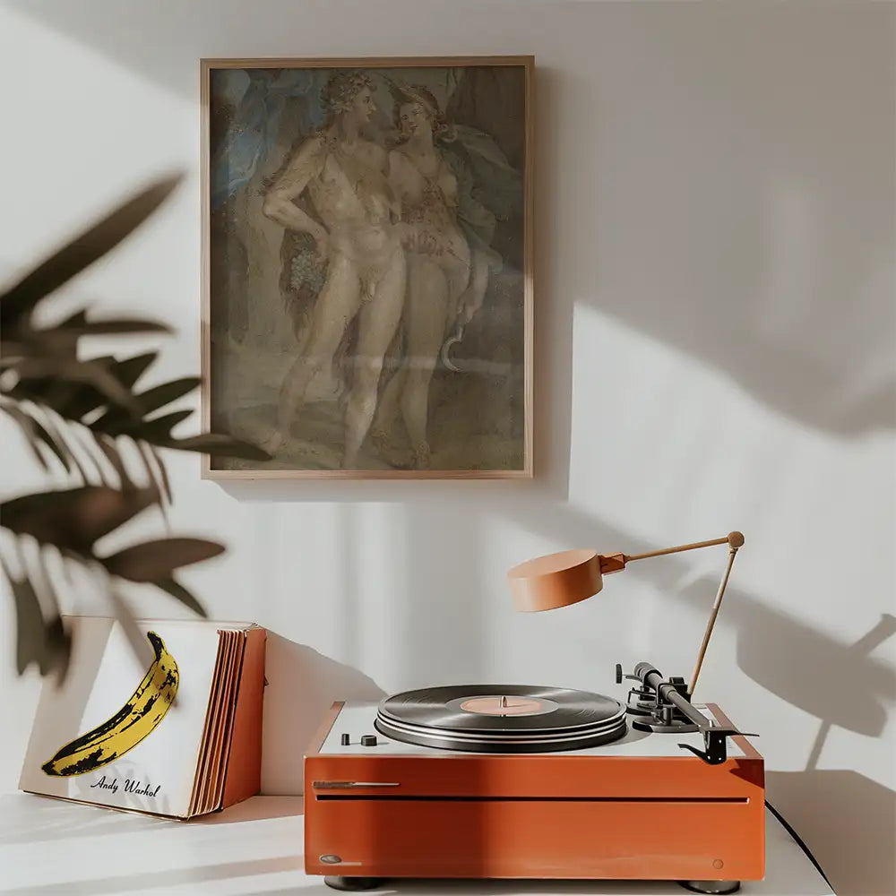 Framed painting of two figures on wall above a vintage turntable with orange accents and vinyl records.
