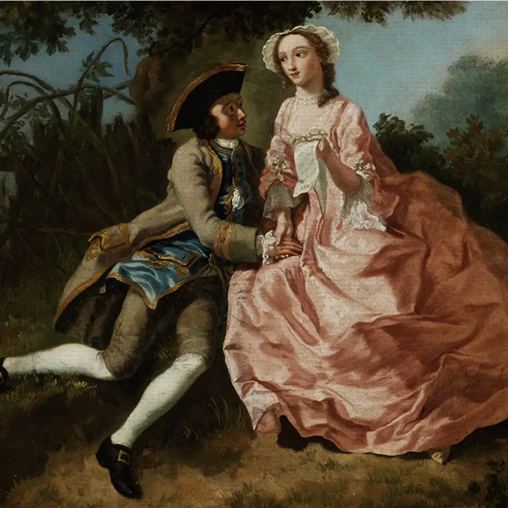 Couple seated in a lush outdoor setting, with the man in historical attire and the woman in a pink dress, both holding hands and gazing at each other.
