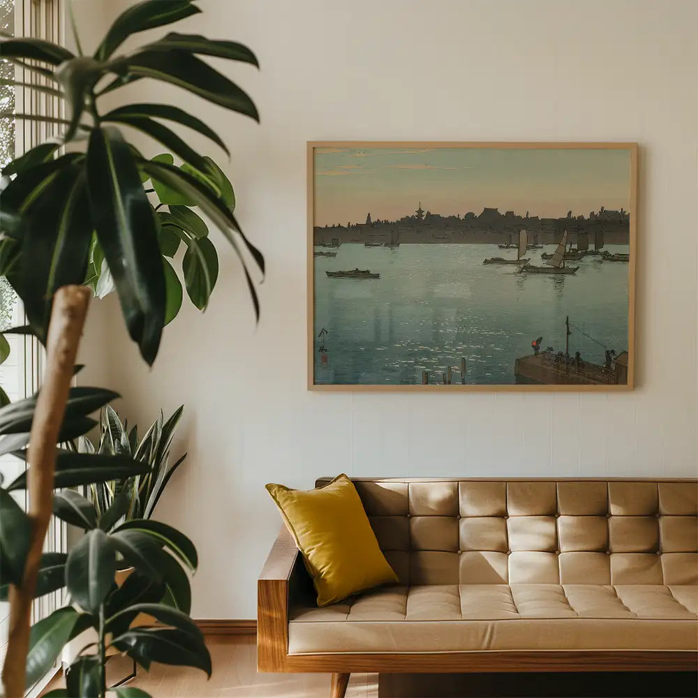 Framed painting of a serene waterway scene with boats, displayed above a modern brown sofa and surrounded by indoor plants.